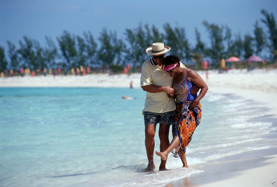 Adults walk along the beach at Castaway Cay