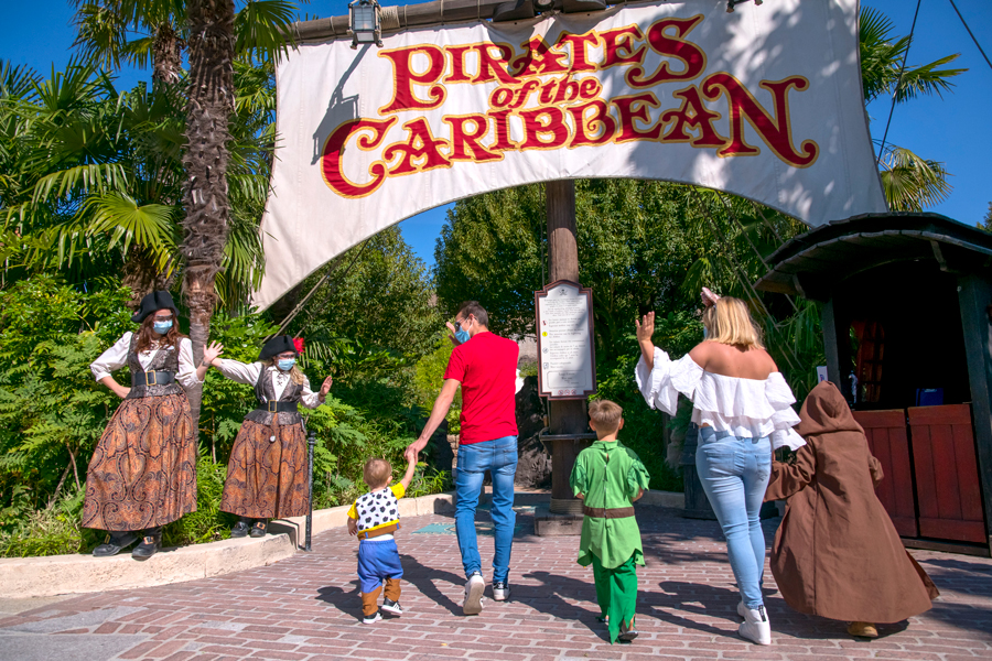 Guests wave to cast members while walking to Pirates of the Caribbean attraction at Disneyland Paris