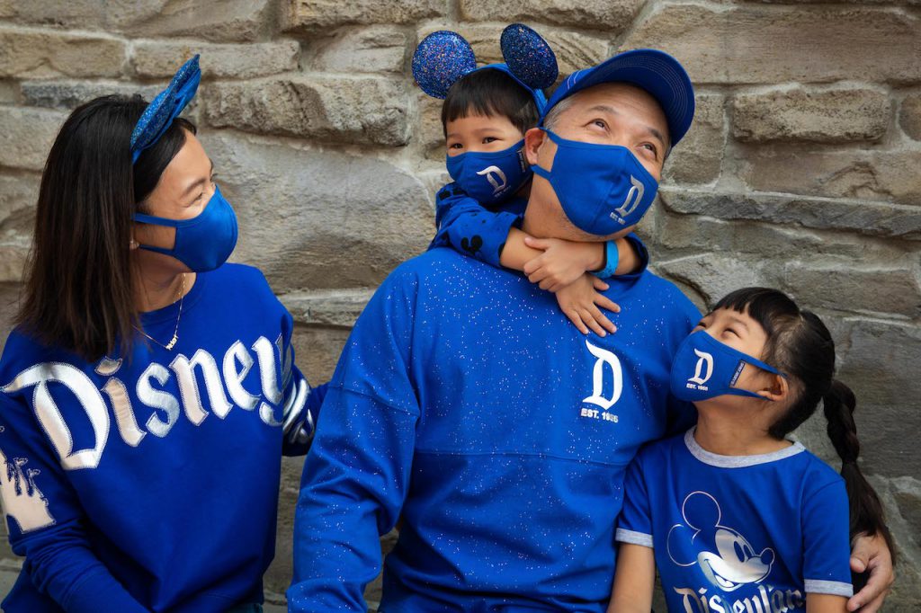 Family in the new Wishes Come True Blue Collection with Disneyland Resort logo