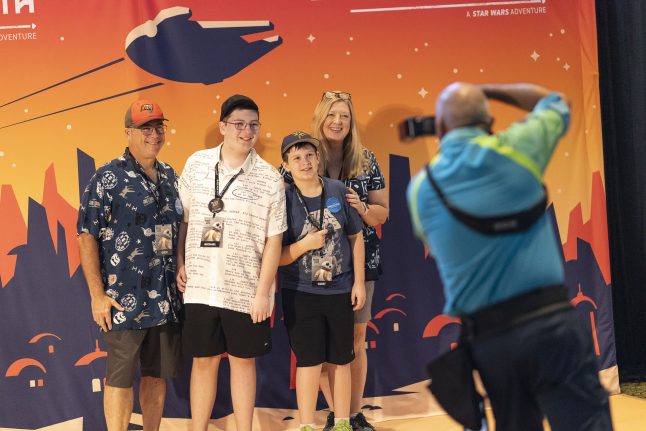 A Make-A-Wish family poses in front of a Star Wars backdrop