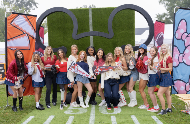 Game Day attendees pose together at a Mickey-themed photo spot