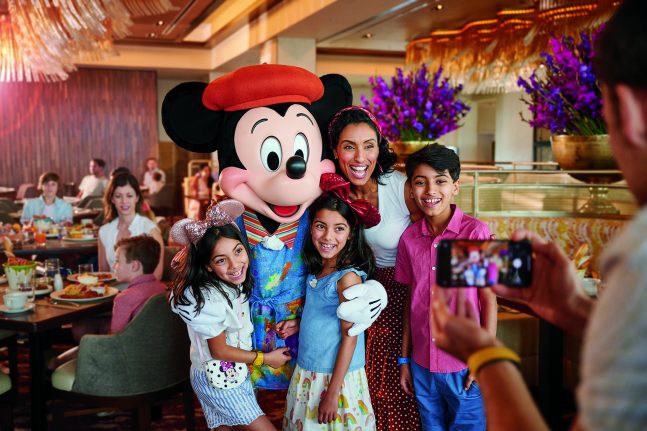 Guests pose with Mickey Mouse at Topolino's Terrace