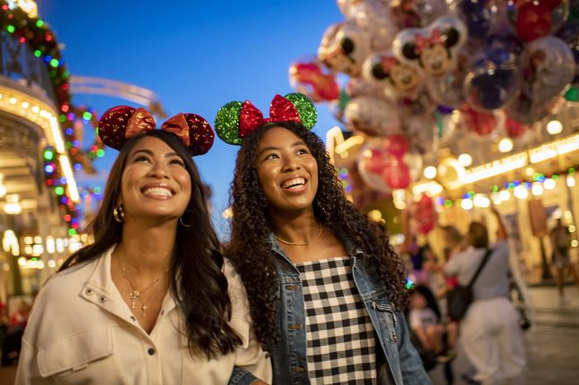 Guests smile on Main Street, U.S.A., decorated for the holidays